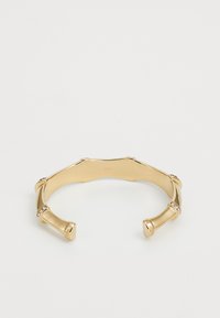 Bracciale in oro con design a bambù, caratterizzato da curve morbide e piccoli accenti di cristallo trasparente. Forma aperta per una facile indossabilità.