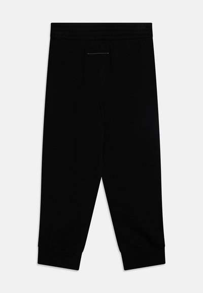 Svarte joggebukser med elastisk midje, innsnevring ved ankelen og en subtil sømdetalj foran. Glatt materiale med matt finish.