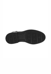 Suela de zapato de goma negra con patrones de agarre texturizados, que presenta formas de estrellas y patrones de líneas variados para una mejor tracción. Diseño plano y exterior duradero.