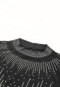 Black short-sleeve top with a high neckline, featuring a design of silver studs arranged in a gradient pattern across the fabric.