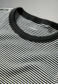 Czarny i biały t-shirt w paski z ribbowym, czarnym okrągłym dekoltem. Materiał ma gładką teksturę z jednolitymi poziomymi paskami.