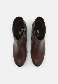 �Καφέ δερμάτινες μποτες κάτω από τον αστράγαλο με λεία υφή, στρογγυλεμένες μύτες και φερμουάρ στο πλάι. Η επιγραφή "Gabor Comfort" είναι ορατή στο εσωτερικό.