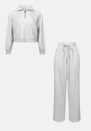 Light grey sweatshirt with a zip collar and front pocket, paired with matching relaxed-fit sweatpants featuring an elastic waistband.