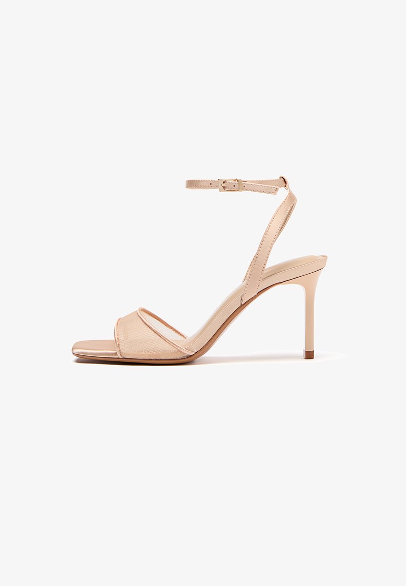 Beige højhælede sandal med tynd rem over tæerne og justerbar ankelstrop med spænde, stilethæl, åben tå-design.