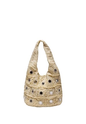 Beige virkattu olkalaukku, jossa on neliökuvioita ja pienten heijastavien pyöreiden peilien keskellä jokaisessa neliössä.