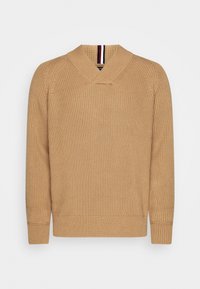 Maglione in beige a maglia con colletto scialle, texture a coste e maniche lunghe. Presenta strisce rosse e bianche a contrasto sul colletto.