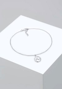 Brățară din lanț argintiu cu un charm circular având un design unduit, închizătoare lobster și lungime ajustabilă. Finisaj metalic lustruit.