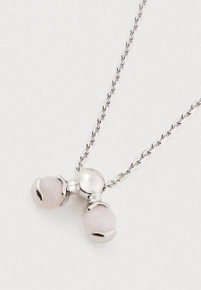 Sidabrinė grandinėlė su pakabuku, kuriame du švelniai rožiniai akmenys, laikomi blizgiame sidabriniame letenos tvirtinime ant balto fono.