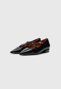 Chaussures en cuir verni noir avec un bout pointu, ornées d'une sangle décorative et d'un petit talon carré. Présente une texture crocodile.