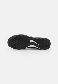 Black athletic shoe sole with textured hexagonal traction patterns and a white Nike swoosh logo. Smooth, durable rubber material.