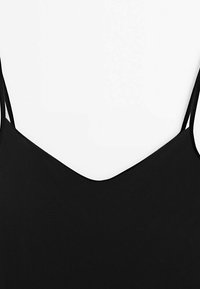 Haut sans manches noir avec un dos en V profond et de fines bretelles, fabriqué en tissu lisse avec une finition mate.