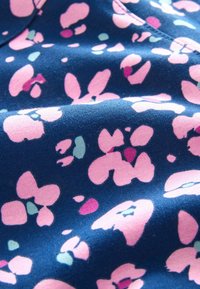 Marineblauwe stof met een bloemenpatroon in roze, paars en groene tinten. Het oppervlak heeft een zachte, textuurlijke uitstraling met een lichte glans.