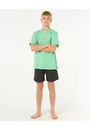 T-shirt en coton vert avec un graphisme de soleil sur la poitrine, associé à un short noir. Le short possède une petite étiquette de marque sur le côté.