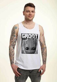 Camiseta sin mangas blanca con un gráfico en blanco y negro de Groot de Marvel en "Guardians of the Galaxy Vol. 2". Material: mezcla de algodón.