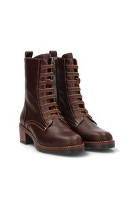 Botas de tobillo de cuero marrón con punta redondeada, cordones en la parte delantera, cremallera lateral y tacón apilado. Costuras en contraste y textura suave.