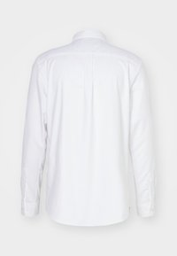 Witte blouse met lange mouwen en een button-down kraag, met een gladde textuur. Details van een rugplooitje en knopenmanchetten. Geen patronen of accenten.