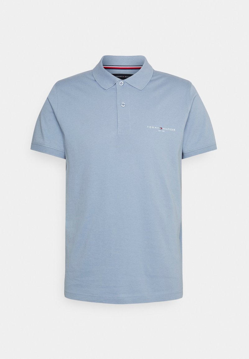 Polo bleu clair en coton. Il présente un col, deux boutons, des manches courtes et un petit logo brodé sur la poitrine.
