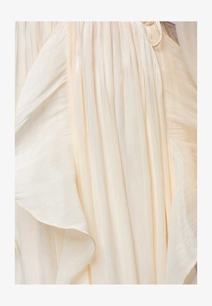 Tissu crème doux et fluide avec de légers plis et un éclat délicat, créant des plis élégants en couches et une texture subtile.