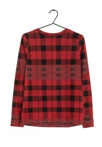 Chemise à manches longues en flanelle à carreaux rouges et noirs, en tissu tricoté, avec un col rond, un ourlet droit et des fentes sur les côtés, suspendue à un crochet noir.