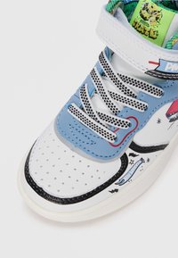 Hoge sneakers met blauwe leer, witte geperforeerde neus, zwarte accenten, kleurrijke voering en unieke grafische ontwerpen aan de zijkanten.