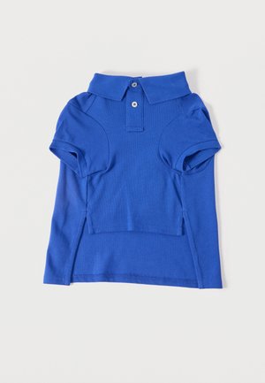 Polo bleu à manches courtes avec col, superposé sur une chemise à manches longues bleu assorti, les deux posés à plat sur un fond blanc.