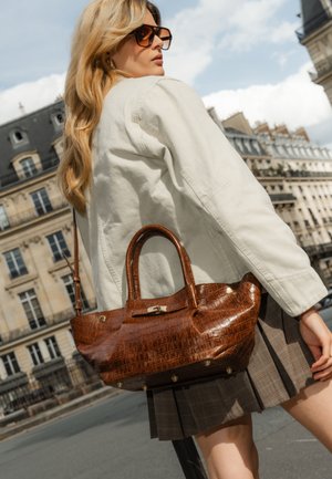 Sac à main en crocodile marron embossé avec deux anses et des détails en matériel doré. Le sac présente une texture lisse et une forme structurée.