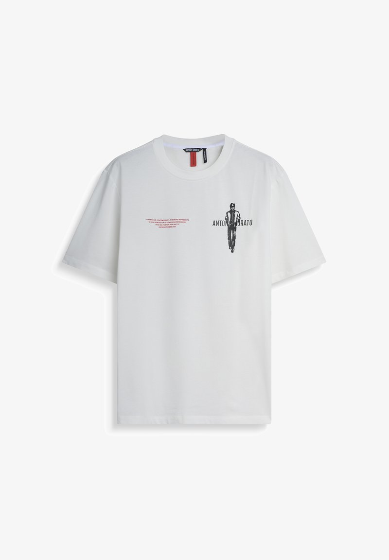 Camiseta de algodón blanca de ajuste holgado, con un estampado gráfico en negro y texto rojo en la parte frontal. Cuello redondo y mangas cortas.