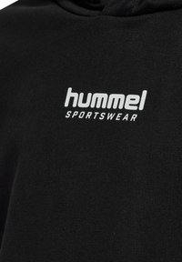 Zwarte hoodie met een zachte textuur en geribbelde zoom. Voorzien van een witte "hummel SPORTSWEAR" logo op de voorkant. Eenvoudig, minimalistisch ontwerp.