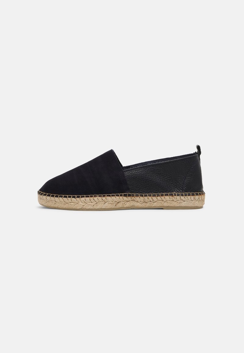 Espadrille noire à enfiler avec une tige en suède, un accent en cuir à l'arrière, une semelle en corde de jute et un design à bout arrondi.