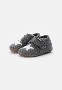 Pantofole grigie in feltro con design a stelle bianche, chiusura con strap in Velcro e suola in gomma marrone, caratterizzate da una superficie morbida e testurizzata.