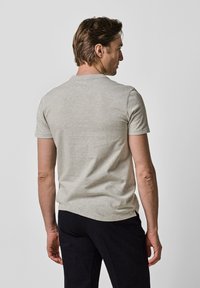 Szara bawełniana koszulka z okrągłym dekoltem, krótkimi rękawami i luźnym krojem. Gładka tekstura i podstawowy design bez wzorów.