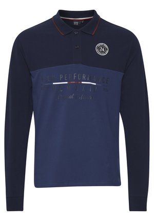Polo tričko s dlouhým rukávem v námořnické modři s kontrastním límečkem, se textovými grafikami a kruhovým logem na hrudi. Materiál je směs bavlny.