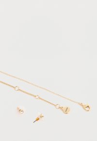 Set di gioielli in oro, composto da una delicata collana con catena e pendente rotondo con chiusura a farfallina, abbinato a due orecchini a perno.