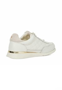 White sneakers with a quilted texture, suede accents in light beige, gold-tone hardware on the heel, and a cushioned sole.