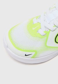 Weißer Sportschuh mit einem Obermaterial aus Mesh und neon-grünen Akzenten, einer gepolsterten Zunge und dem schwarzen Nike-Logo, das ein leichtes Design präsentiert.
