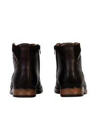 Botas de tobillo de cuero marrón con un acabado suave, cremalleras traseras y un tacón de madera clara en contraste. Diseño simple, sin patrones visibles ni herrajes.