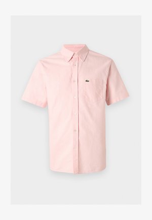 Világos rózsaszín rövid ujjú, gombos ing hegyes gallérral és mellzsebbel, amelyen egy kis zöld krokodillogó található.