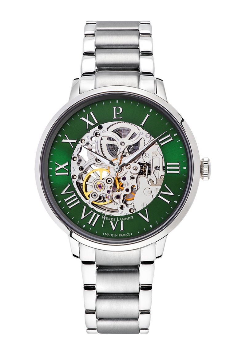 Sølv rustfrit stål automatisk ur med skeletdial, grøn baggrund og romerske tal. Har synlige gear og en poleret finish.
