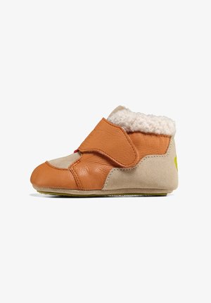 Chaussures pour tout-petits en cuir et daim, couleur tan et crème, avec une doublure en peluche, une sangle Velcro et une semelle en caoutchouc flexible.