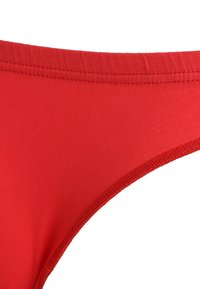 Rød bikiniunderdel i et glat, strækbart stof. Har et lavtskåret design med rene kanter og minimal syning.