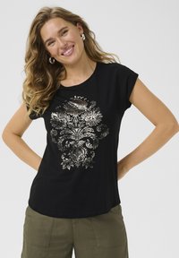 Zwart T-shirt met een metallic bloemenontwerp, korte mouwen en een ronde halslijn, gecombineerd met olijfgroene broeken.