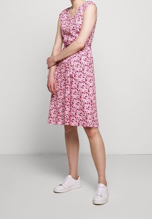 Kukkakuvioinen vaaleanpunainen mekko, jossa on lyhyet hihat, V-pääntie, vyötäröä korostava malli ja väljät hameet. Yhdistetty valkoisiin tennareihin rentoa ilmettä varten.