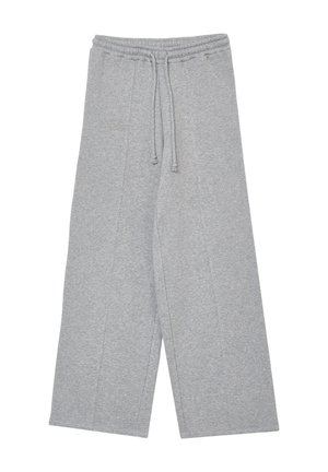 Pantaloni della tuta grigi, ampi e con elastico in vita e cordoncino regolabile. Tessuto morbido con cuciture a vista e senza tasche.