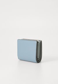 Lyseblå skinnlommebok med teksturert overflate, med et kompakt, bi-fold design og grønne interiørdetaljer. Stikking i kantene.