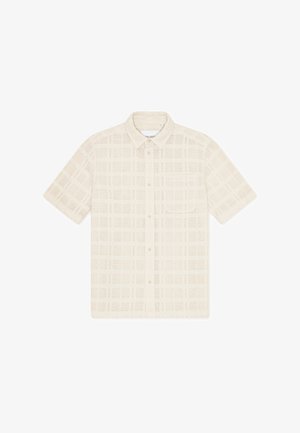 Rövid ujjú, galléros ing bézs színű anyagból, texturált rácsmintával és mellzsebbel. Gombos záródású és légáteresztő kialakítású.