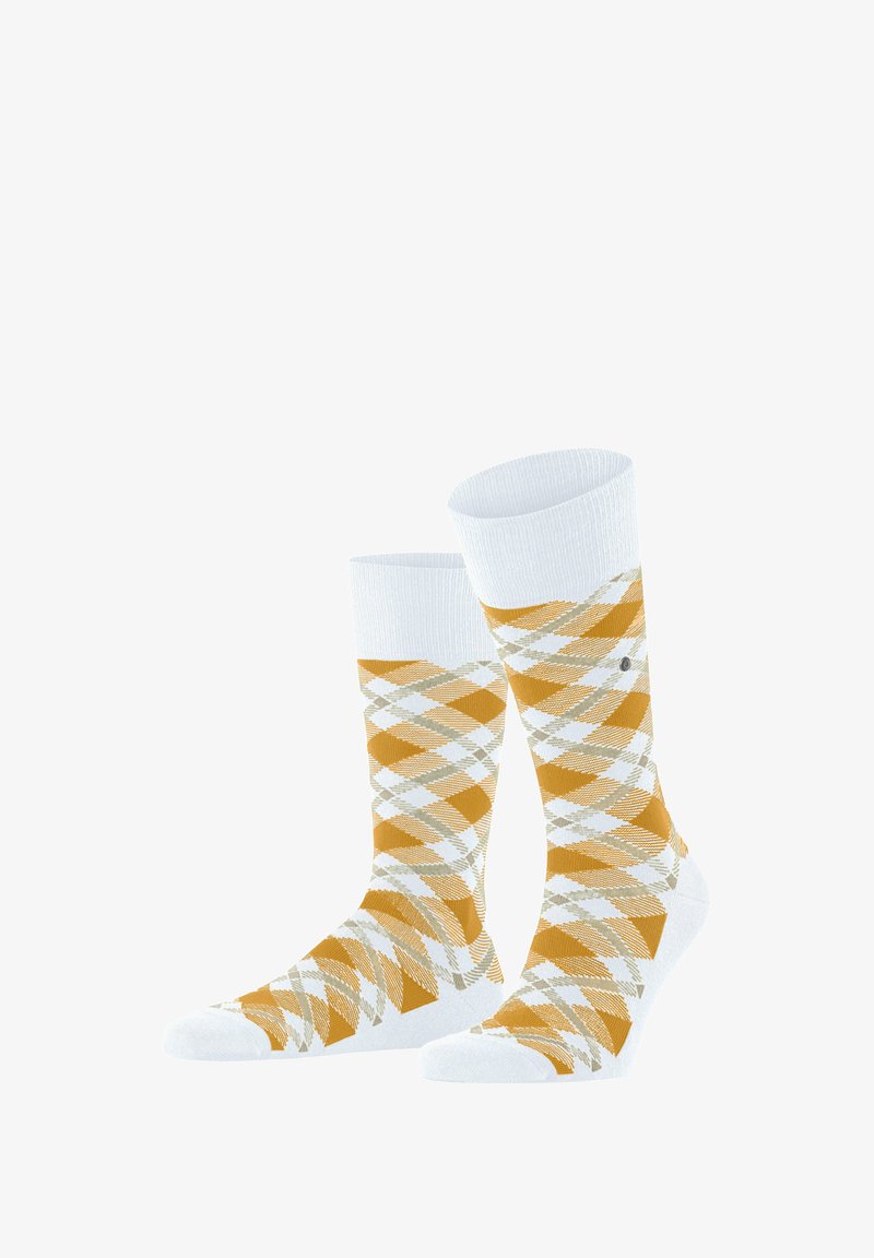 Chaussettes blanches avec un motif losange jaune et beige, des poignets côtelés et un petit logo circulaire sur le côté.