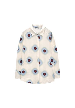 Kremowa koszula z długim rękawem, ozdobiona niebieskimi wzorami w kształcie diamentów z czerwonymi okrągłymi środkami, zapinana na guziki, z klasycznym kołnierzem.