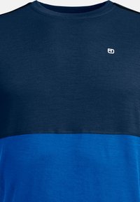 Short-sleeve T-shirt in navy blue and bright blue. Features a textured finish with a crew neck and a small logo on the chest.