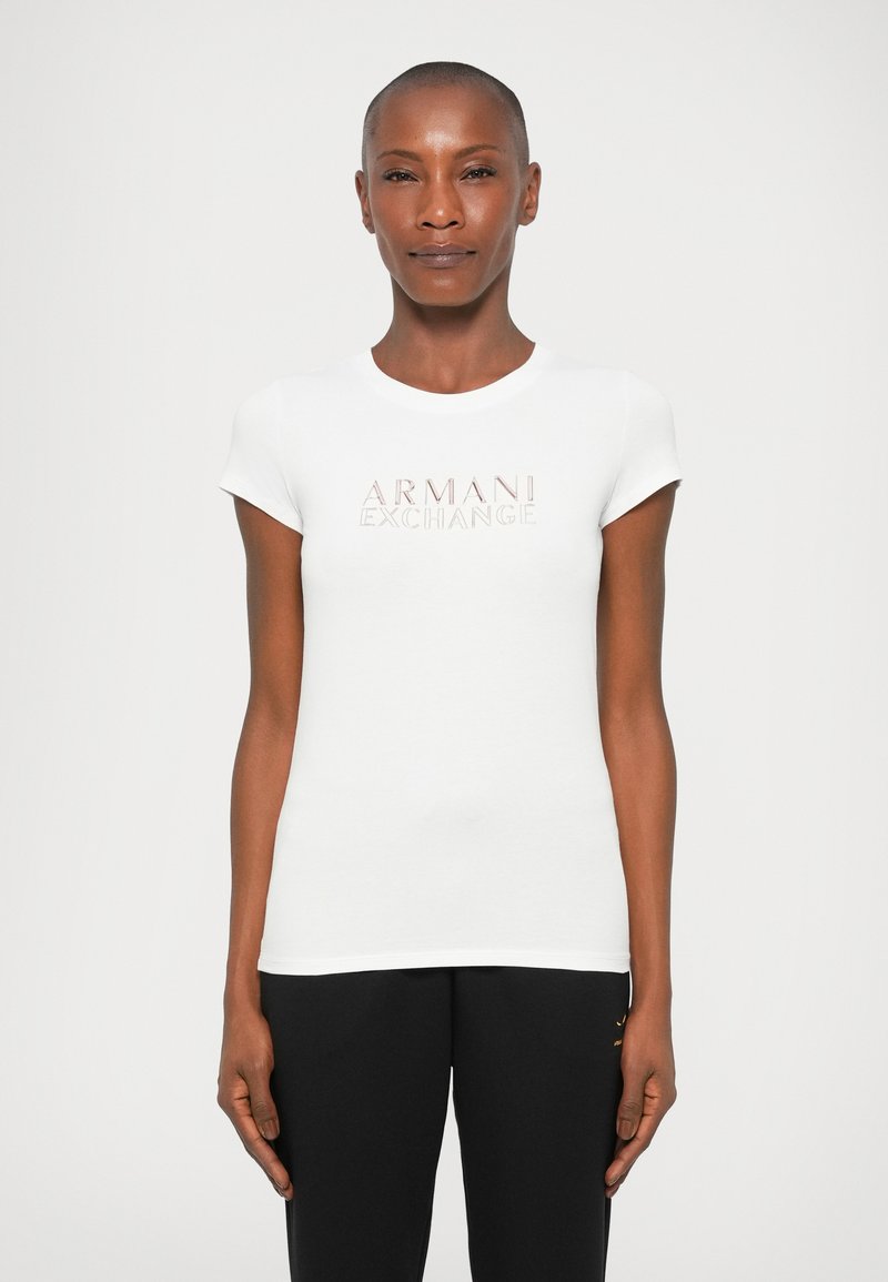 Biela bavlnená tričko s okrúhlym výstrihom a krátkymi rukávmi, s jemným ružovým logom "ARMANI EXCHANGE" na prednej strane.