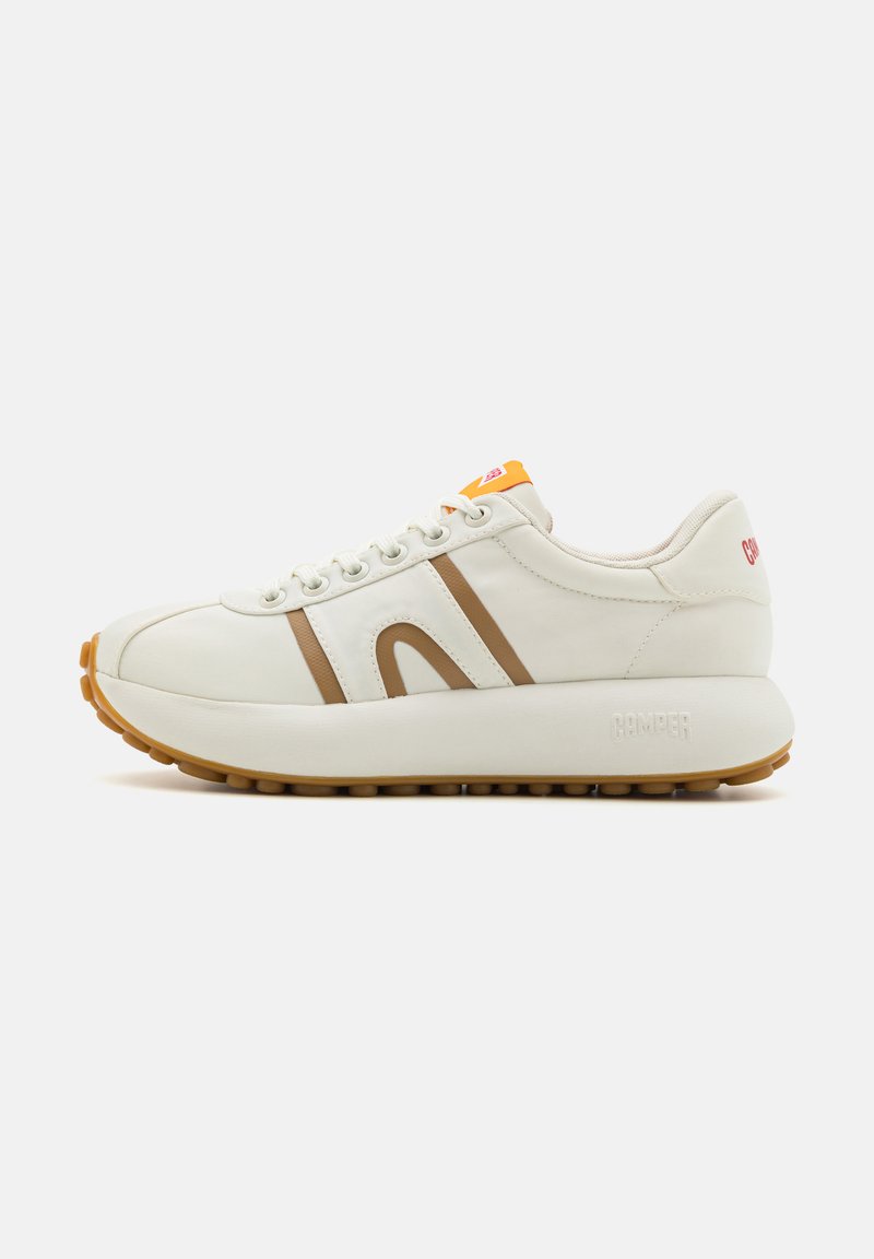 Vit sneaker med bruna ränder och orange accent, med en tjock sula och rund tå. Texturerad ovandel med snörning och varumärkesdetalj.